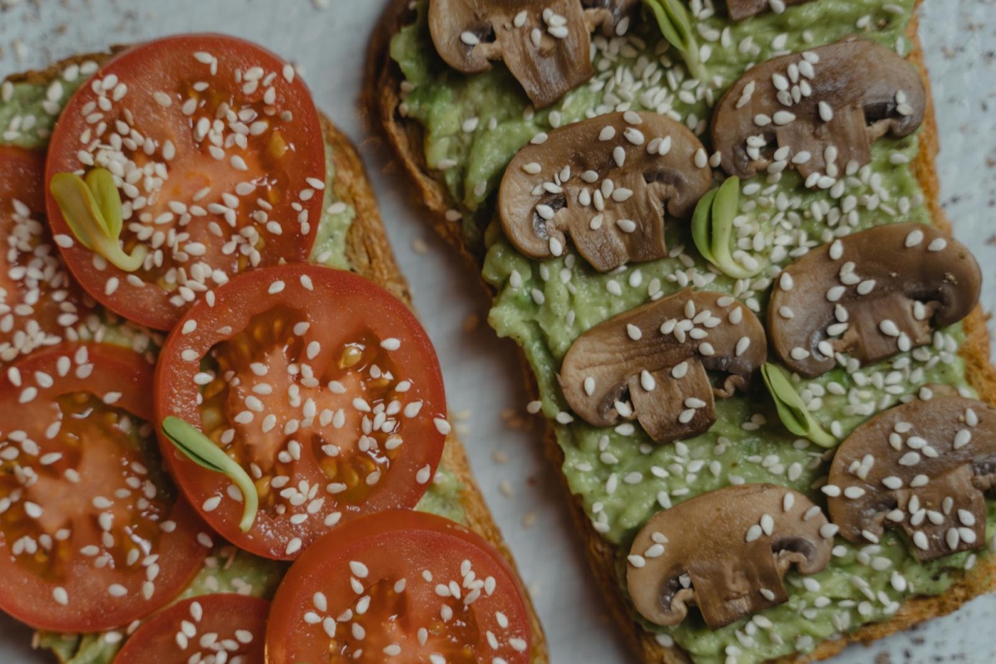 Tartines avocat-champignons et avocat-tomate aux graines de sésame, gros plan végétarien